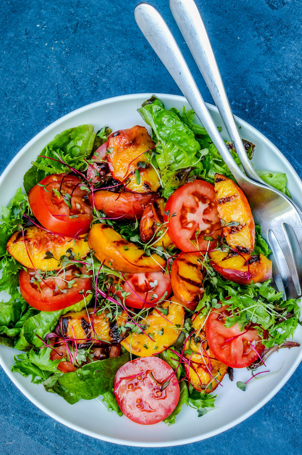 Si vous êtes intéressé par de nouvelles saveurs, essayez cette recette: ajoutez des pêches grillées à votre salade de tomates et de laitue.
