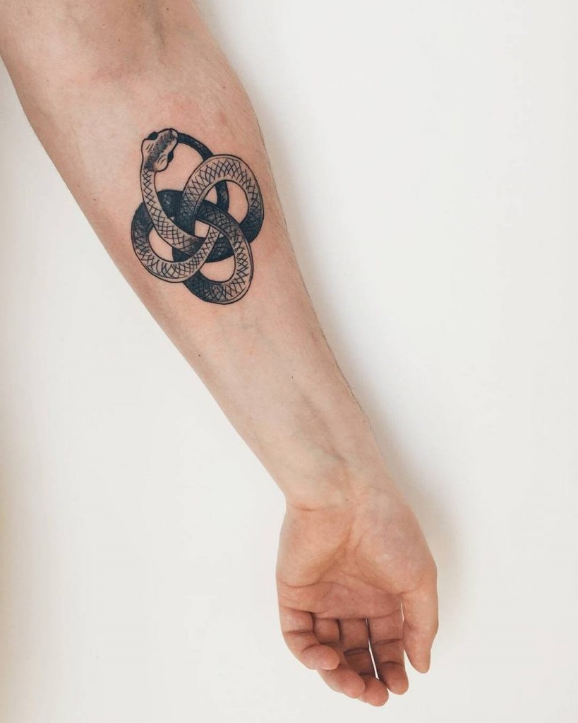Ouroboros tatoué sur le bras.